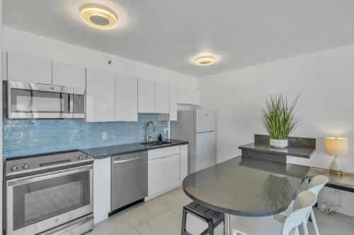 a kitchen with white appliances and a table with chairs at Standard Ocean View Condo - 36th Floor, Free parking & Wifi condo in Honolulu