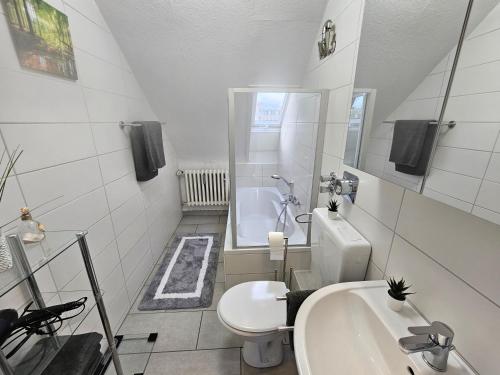 La salle de bains blanche est pourvue de toilettes et d'un lavabo. dans l'établissement Exklusives und helles Dachgeschoss-Apartment No 3 im Zentrum von Kassel, schnelles 1Gbit Internet, Geschirrspüler, Boxspringbetten, à Cassel
