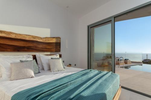 a bedroom with a bed with a view of the ocean at Sky Birds Villa - Holistic Escape in Skinária