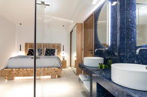 a bedroom with a bed and two sinks and a tub at Sky Birds Villa - Holistic Escape in Skinária