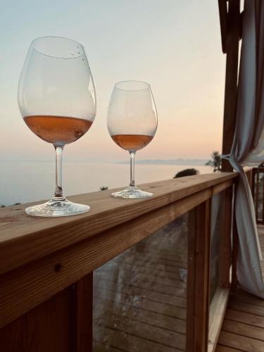 two glasses of wine sitting on a rail at Mobile Evasion okpl BEAUVOIR in Saint-Raphaël