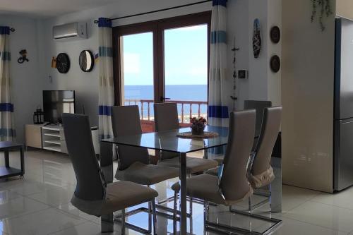 a dining room with a table and chairs with a balcony at Apartamento Neptuno in Candelaria