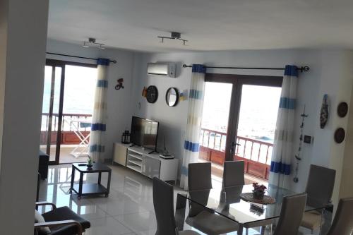 a living room with a television and a balcony at Apartamento Neptuno in Candelaria