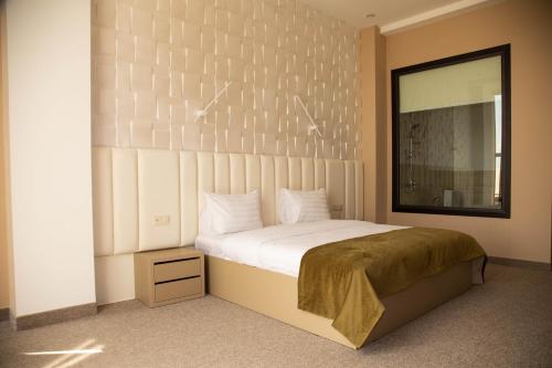 a bedroom with a large bed and a mirror at Port Plaza YVN in Pʼarakʼar
