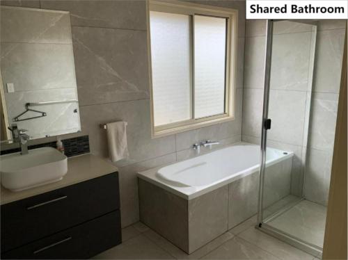 a bathroom with a tub and a sink and a shower at Shared house with other guests near shopping center and theme parks in Gold Coast