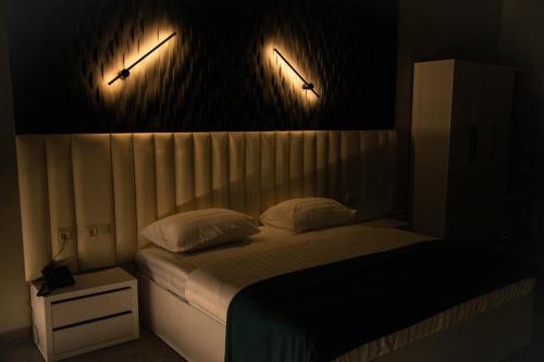 a bedroom with a bed with two lights on the wall at Port Plaza YVN in Pʼarakʼar