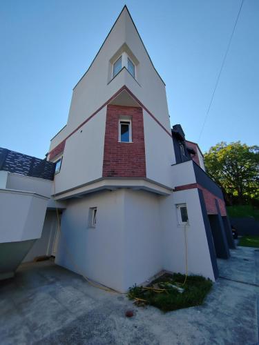 a large white building with a large garage at Hedonic Wellness Apartmani in Niš