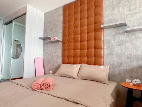 a bedroom with a bed with two pink towels on it at Duplex 4px @ Direct Linked to Central I-CITY & SOGO with Free Carpark in Shah Alam