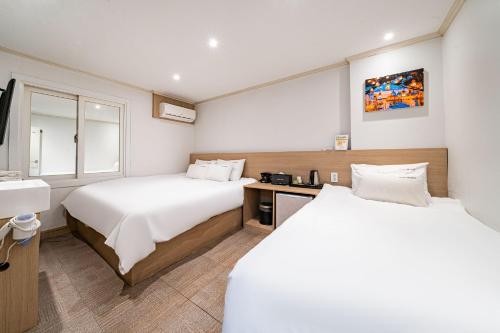 a hotel room with two beds and a sink at WABA Classic Gwanganri in Busan