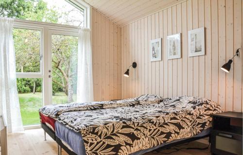 ein Schlafzimmer mit einem Bett in einem Zimmer mit einem Fenster in der Unterkunft Gorgeous Home In Dronningmlle With Wifi in Dronningmølle
