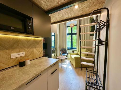 a small kitchen with a staircase in a tiny house at Loft Apartments Gliwice in Gliwice