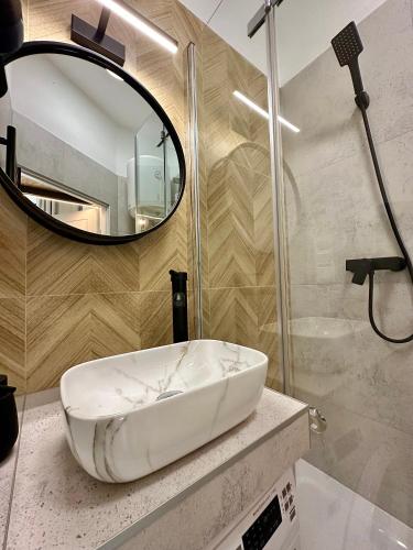 a bathroom with a white sink and a mirror at Loft Apartments Gliwice in Gliwice