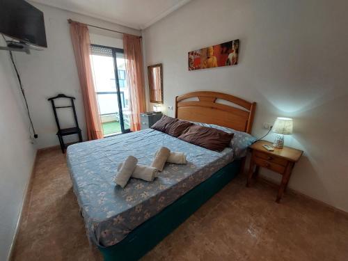 een slaapkamer met een bed met 2 kussens erop bij Apartamento Playa Mar 303 in Playas de Orihuela