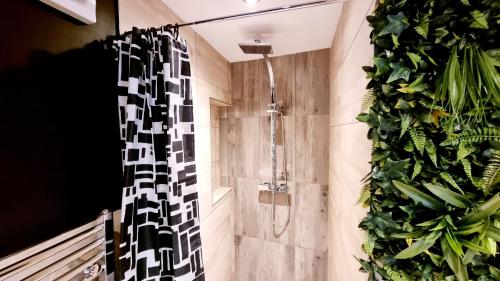 a bathroom with a shower with a plant at Bed& Boujee by the pier in Paignton