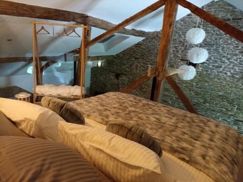 a room with four beds and a stone wall at Loft blanc (baignoire balnéo et sauna) in Trois-Ponts