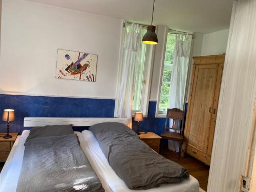 a bedroom with a bed and a blue wall at Flett - Artlands Home - Landhaus für Familien und Gruppen in Badbergen