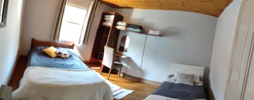 a bedroom with two beds and a window at Recanto Dorinha in Campos do Jordão