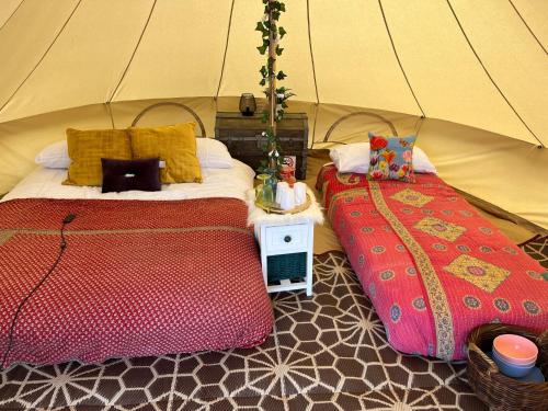 a bedroom with two beds in a tent at Hawthorne Field - Shoreline Escapes in Bransgore