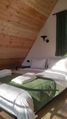 two beds in a room with a wooden ceiling at Cottage Milo Kazbegi in Kazbegi