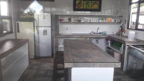 a kitchen with a refrigerator and a table in it at Finca Hotel El SAMAN de alto bonito in Montenegro