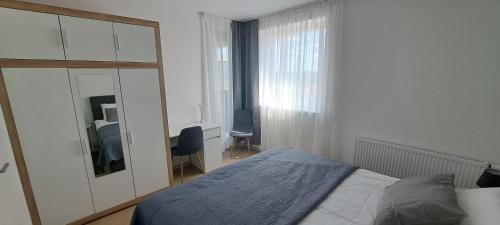 een slaapkamer met een bed, een spiegel en een bureau bij Apartment Varaždin in Varaždin