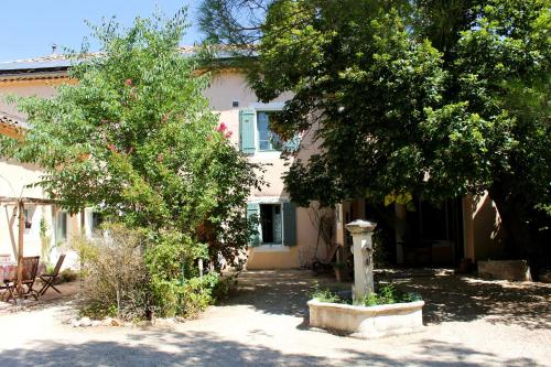 une maison avec deux arbres et une bouche d'incendie dans l'établissement NEW! Gîtes de Charme au Mas de Soleil, à Goudargues