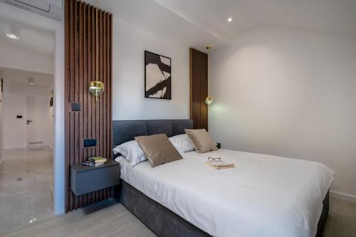 a bedroom with a large white bed with a side table at Luxury Suite All You Need in Dubrovnik