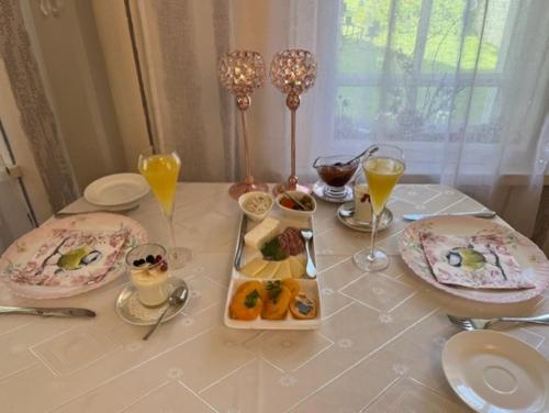 a table with plates of food and glasses of orange juice at Altja Villa-Cottage with sauna in Altja