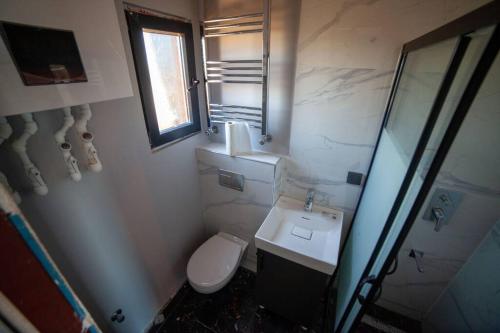 a bathroom with a toilet and a sink and a window at Boutique hotel with a heat pool in Dosemealti