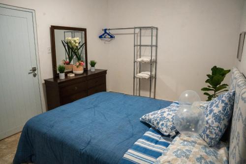 a bedroom with a bed with a blue comforter at Casa Maria Luquillo PR in Luquillo