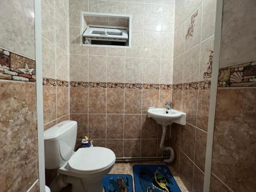 ein Bad mit einem WC und einem Waschbecken in der Unterkunft Guest House Dinara in Kaji-Say