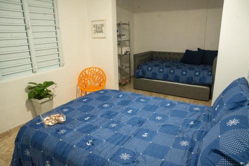 a bedroom with a bed with a blue blanket at Casa Maria Luquillo PR in Luquillo