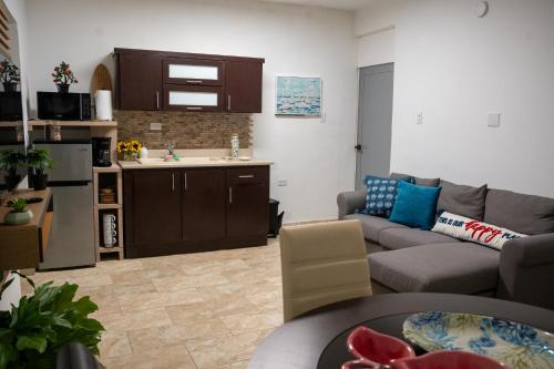 een woonkamer met een bank en een keuken bij Casa Maria Luquillo PR in Luquillo