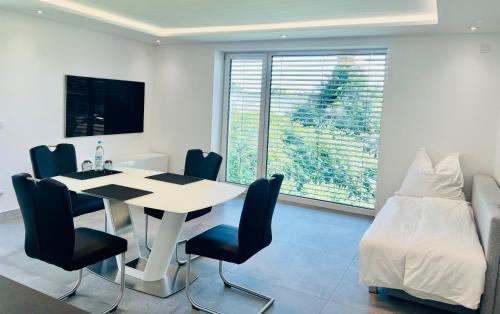 a dining room with a table and chairs and a bed at City Apartments in Herzogenaurach