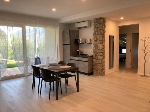 una cucina e una sala da pranzo con tavolo e sedie di La Casa sul Lago Apartments - Olive Tree Apartment a Limone sul Garda