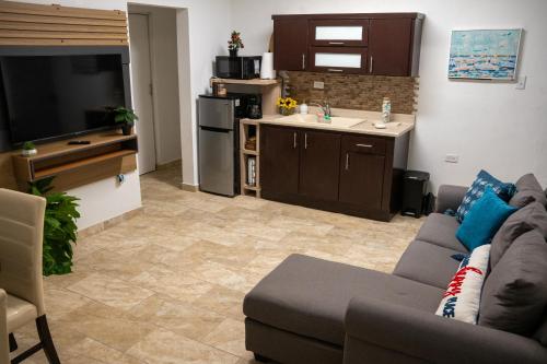 a living room with a couch and a kitchen at Casa Maria Luquillo PR in Luquillo