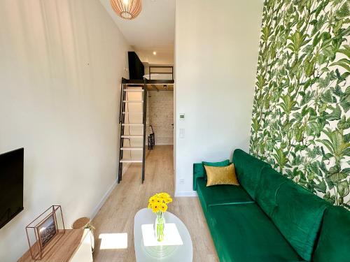 a living room with a green couch and a table at Loft Apartments Gliwice in Gliwice