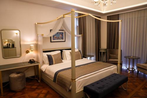 a bedroom with a canopy bed and a mirror at ARCHSTONE BY KETENCİ HOTEL in Konak