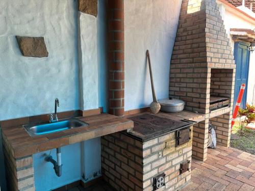 una cocina al aire libre con fregadero y un horno de ladrillo en Casa Victoria en Zapatoca