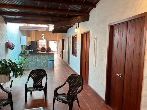- un couloir avec deux chaises et une table dans une maison dans l'établissement Casa Victoria, à Zapatoca