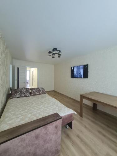 een slaapkamer met een bed en een tv aan de muur bij Двокімнатні апартаменти in Loetsk