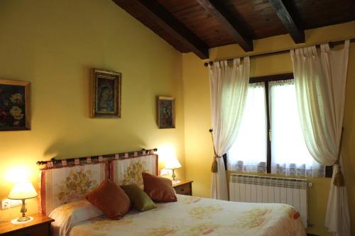 a bedroom with a bed with two lamps and a window at Agroturismo Atxarmin in Elosu