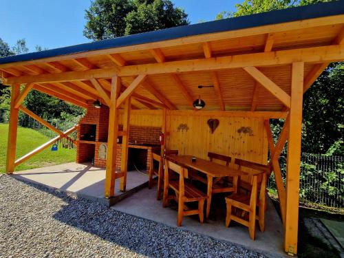 a wooden pavilion with a wooden table and chairs at Casa Emmara Sighisoara in Sighişoara