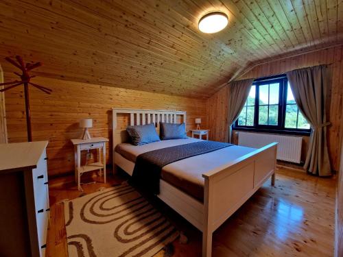 a bedroom with a bed in a wooden room at Casa Emmara Sighisoara in Daneş