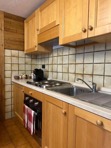 a kitchen with a sink and a stove at Hotel Du Grand Paradis - 1899 Auberge Boutique in Cogne