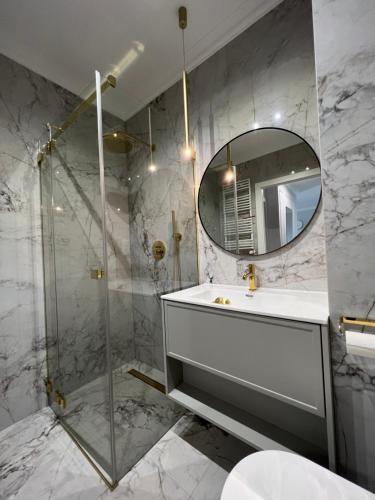 La salle de bains est pourvue d'un lavabo et d'un miroir. dans l'établissement Bella Casa Luxury Apartament, à Radom