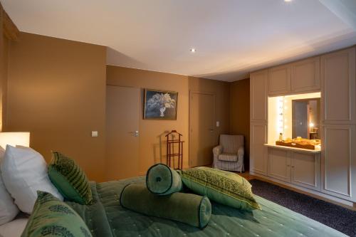 - une chambre avec un lit et des oreillers verts dans l'établissement Le Nid de la Canette, à Durbuy
