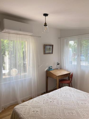 a bedroom with a bed and a desk and a window at Gîte cosy in Orange