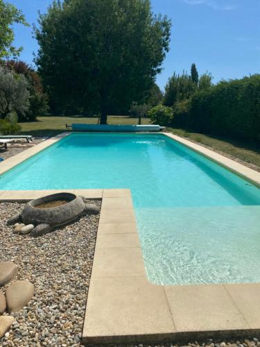- une piscine bleue avec une courbe en pierre dans l'établissement Gîte cosy, à Orange