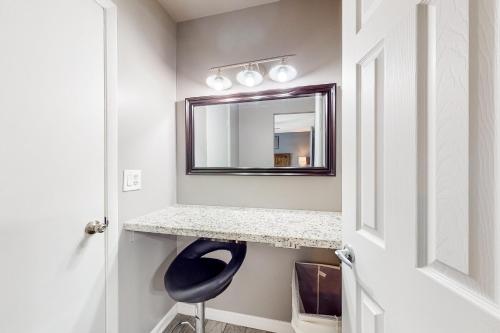 a bathroom with a mirror and a blue chair at Paradise Palms in Scottsdale